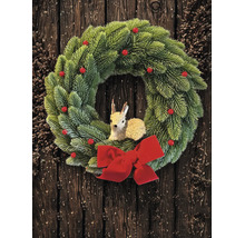Grüner Weihnachtskranz aus künstlichem Tannengrün mit roten Beeren, einer Rehfigur in der Mitte und einer großen roten Schleife vor dunklem Holz.