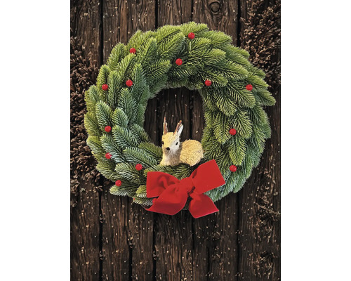 Grüner Weihnachtskranz aus künstlichem Tannengrün mit roten Beeren, einer Rehfigur in der Mitte und einer großen roten Schleife vor dunklem Holz.