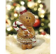 Lebkuchenfigur als Mädchen mit Zuckerstange und roter Schleife, Weihnachtsdekoration vor festlichem Hintergrund.