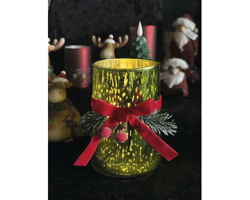 Weihnachtliches Windlicht aus grünem Glas mit roter Schleife, Tannenzweigen und Beeren.
