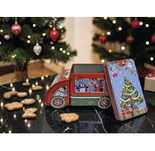 Weihnachts-Guetzlidose aus Metall in Lastwagenform mit Motiven auf einer dunklen Fläche neben Lebkuchen und einem Weihnachtsbaum.