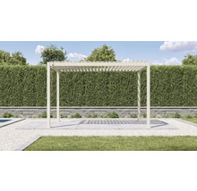 Pergola autoportante avec toit à lamelles en aluminium beige sur une terrasse dans un jardin devant une haie.