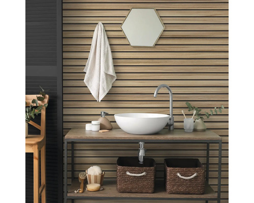 Salle de bain moderne avec panneaux muraux en lattes de bois, vasque à poser blanche sur une étagère en bois et miroir hexagonal.