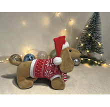 Plüsch-Dackel mit rot-weißem Weihnachtspullover und Weihnachtsmütze in einer festlichen Szene mit kleinem Weihnachtsbaum und Christbaumkugeln.