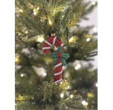 Weihnachtsbaumanhänger Zuckerstange rot und weiß mit Glitzer, dekoriert mit grüner Stechpalme, hängend an einem Weihnachtsbaum.