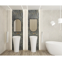 Salle de bains moderne avec deux lavabos colonnes blancs devant du marbre foncé, deux miroirs, robinetterie dorée et baignoire îlot.