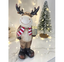 Weihnachtsdekoration Rentier-Figur mit Schal, Stiefeln und Geschenkbox vor einem kleinen Weihnachtsbaum.