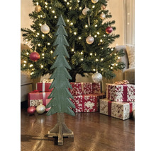 Dekorativer Weihnachtsbaum aus Holz vor einem geschmückten Tannenbaum mit Geschenken und Lichterkette.