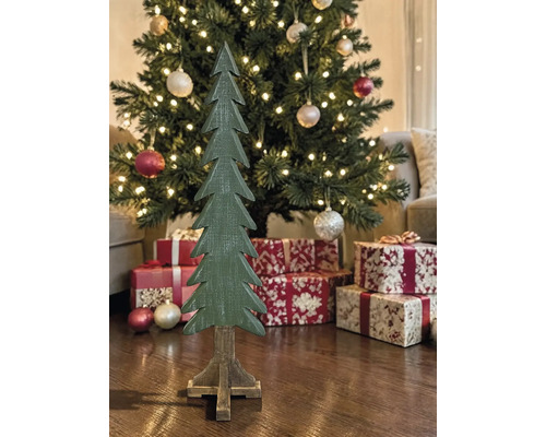 Dekorativer Weihnachtsbaum aus Holz vor einem geschmückten Tannenbaum mit Geschenken und Lichterkette.