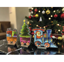 Train de Noël décoratif avec locomotive, Père Noël, sapin et wagons de cadeaux sur une table devant un sapin de Noël illuminé.