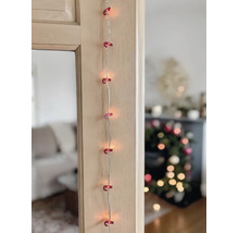 LED-Lichterkette mit rot-weißen Zuckerstangen-Motiven an einem Holzrahmen in weihnachtlicher Umgebung.