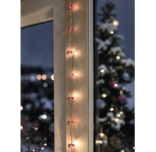 LED-Lichterkette mit Zuckerstangen-Motiven vertikal an einem Holzrahmen angebracht, im Hintergrund ein geschmückter Tannenbaum.