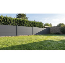 Clôture pare-vue moderne composée de panneaux horizontaux gris anthracite dans un jardin avec pelouse et haie.