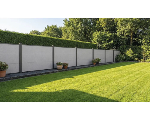 Clôture pare-vue moderne en plaques de fibrociment gris avec poteaux métalliques foncés dans un jardin avec pelouse et haie.