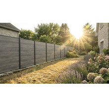 Clôture de jardin moderne avec des lattes horizontales en composite aspect bois et des poteaux en métal sombre dans un jardin ensoleillé.