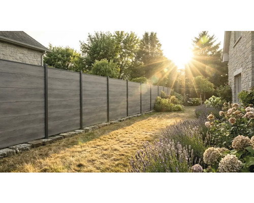Clôture de jardin moderne avec des lattes horizontales en composite aspect bois et des poteaux en métal sombre dans un jardin ensoleillé.