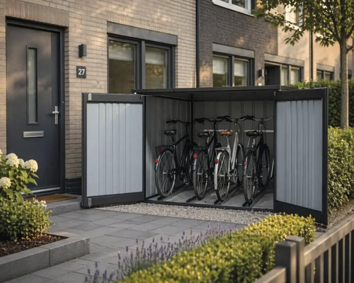 Moderne Fahrradbox aus Metall mit geöffneten Doppeltüren und vier Fahrrädern vor einem Hauseingang mit Ziegelwand, wirkt organisiert.