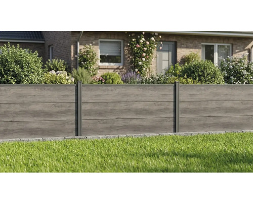 Clôture pare-vue en panneaux d'aspect bois devant un jardin avec pelouse et maison en arrière-plan.