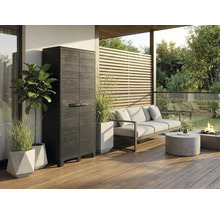 Armoire de jardin haute avec aspect bois sur une terrasse moderne avec salon de jardin et plantes.