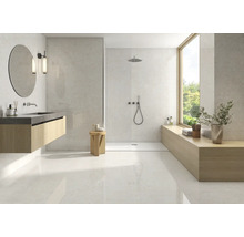 Salle de bains moderne et lumineuse avec carrelage grand format aspect pierre naturelle, douche à l'italienne et meuble vasque en bois.