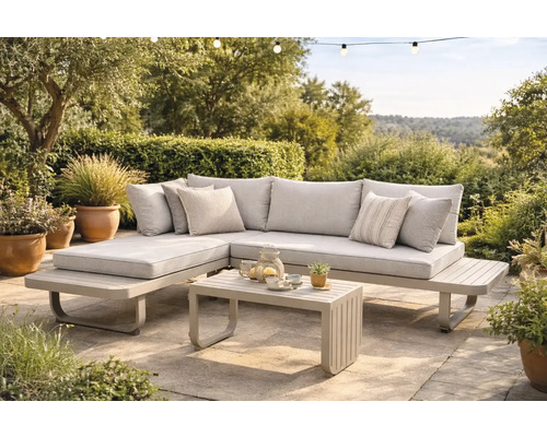 Salon de jardin moderne en métal avec coussins en tissu comprenant un canapé d angle et une table basse sur une terrasse pavée.