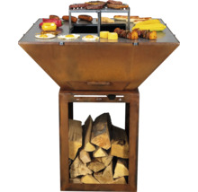 Quadratische Feuerschale aus Metall mit integriertem Holzfach und umlaufender Grillplatte, belegt mit Grillgut.