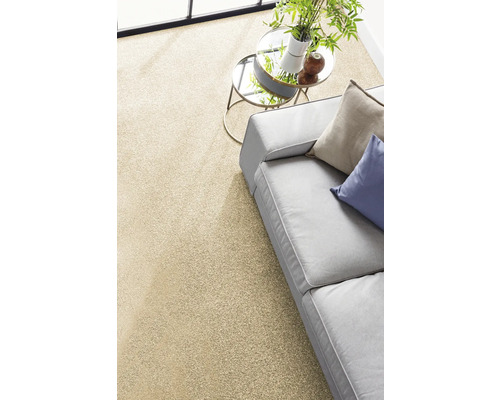 Heller Teppichboden in einem modernen Wohnzimmer mit grauem Sofa und rundem Beistelltisch.