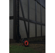 LED-Lichterkette auf Kabeltrommel für den Außenbereich, um ein Fallrohr an einer Hauswand gewickelt.