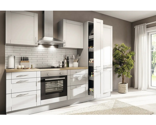 Cuisine moderne et lumineuse avec façades blanches, plan de travail en bois, four, hotte aspirante et armoire à provisions coulissante.