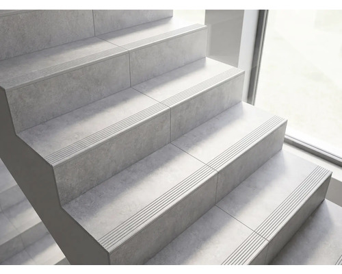 Treppe mit Fliesen in Steinoptik und Sicherheitsrillen an den Stufenkanten.
