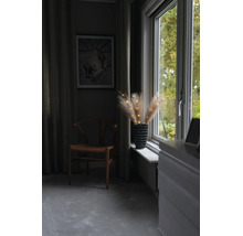 Herbes de pampa lumineuses dans un vase sur un rebord de fenêtre à côté d une chaise en bois dans une pièce chaleureuse.