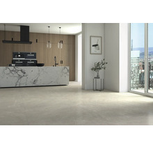 Espace de vie moderne et lumineux avec de grands carreaux de sol aspect pierre, îlot de cuisine aspect marbre et façades en bois.