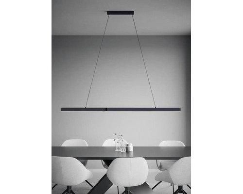 Salle à manger moderne avec une suspension linéaire au-dessus d'une table avec des chaises au design minimaliste.