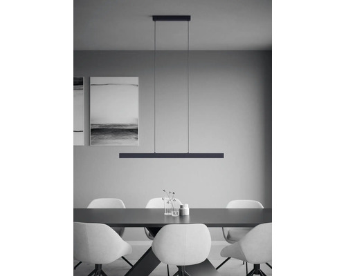 Salle à manger minimaliste avec une suspension linéaire au-dessus d une table sombre, des chaises blanches et une décoration murale moderne.