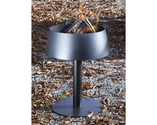 Moderne schwarze Feuerschale aus Metall auf einem Standfuß mit brennenden Holzscheiten.