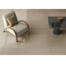 Carreaux de sol lisses de grand format en beige clair dans un salon moderne avec fauteuil et table basse.