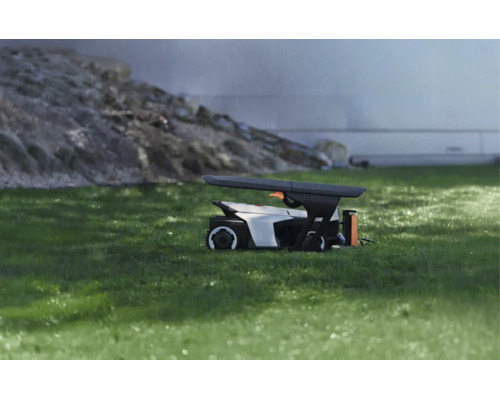 Abri de protection moderne pour robot tondeuse sur pelouse sous la pluie, design fonctionnel pour la protection contre les intempéries.