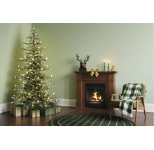 Festlich dekoriertes Wohnzimmer mit beleuchtetem Weihnachtsbaum, Geschenken, Holzkamin mit brennendem Feuer und Sessel mit karierter Decke.