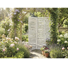 Paravent trois panneaux en bois blanc fait de branches dans un jardin lumineux avec roses, lavande et une arche fleurie.