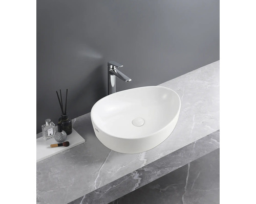 Ovales Aufsatzwaschbecken in Weiss auf einer Arbeitsplatte in Marmoroptik mit verchromter Armatur.