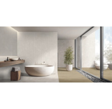 Salle de bain moderne avec baignoire ronde en pierre naturelle, plan vasque en bois et grandes baies vitrées avec vue sur le jardin.