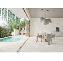 Salle à manger moderne et terrasse avec de grands carreaux aspect pierre naturelle, piscine et végétation luxuriante.