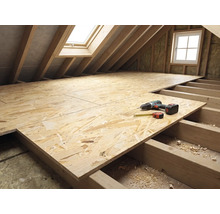Dachstockausbau mit OSB-Platten auf Holzbalken, Akkuschrauber und Rollmeter auf der Verlegefläche im hellen Dachraum.