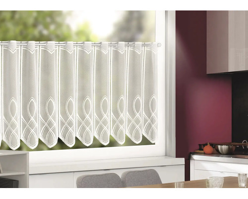 Rideau brise-bise blanc semi-transparent avec broderie et bordure festonnée sur une tringle devant une fenêtre de cuisine.