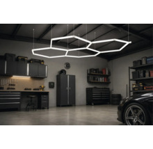 Moderne Garage mit hexagonaler LED-Deckenbeleuchtung, Werkbank, Schränken und organisierter Werkzeugaufbewahrung.