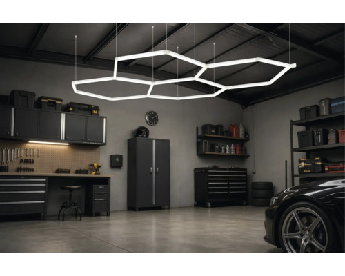 Moderne Garage mit hexagonaler LED-Deckenbeleuchtung, Werkbank, Schränken und organisierter Werkzeugaufbewahrung.