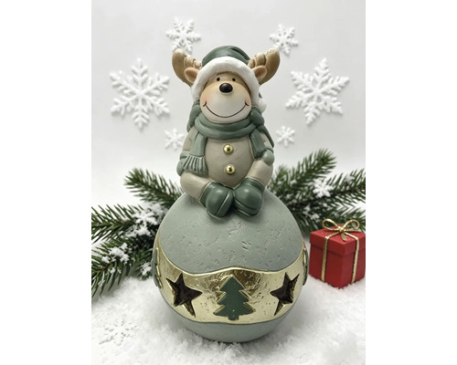 Décoration de Noël renne sur boule avec bonnet, écharpe et gants, scène d'hiver avec branches de sapin et cadeau.