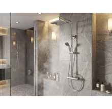 Système de douche moderne avec pomme de douche à effet pluie, douchette à main et mitigeur thermostatique dans une douche carrelée.