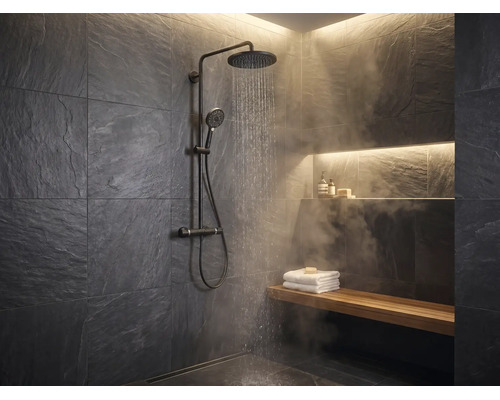 Modernes Badezimmer mit schwarzer Regendusche, dunklen Schieferwänden, Holzbank mit weißen Handtüchern und Wasserdampf.