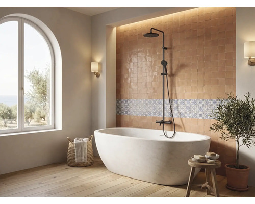 Helles Badezimmer mit freistehender Badewanne, schwarzem Duschsystem, Fliesenspiegel und grossem Rundbogenfenster.